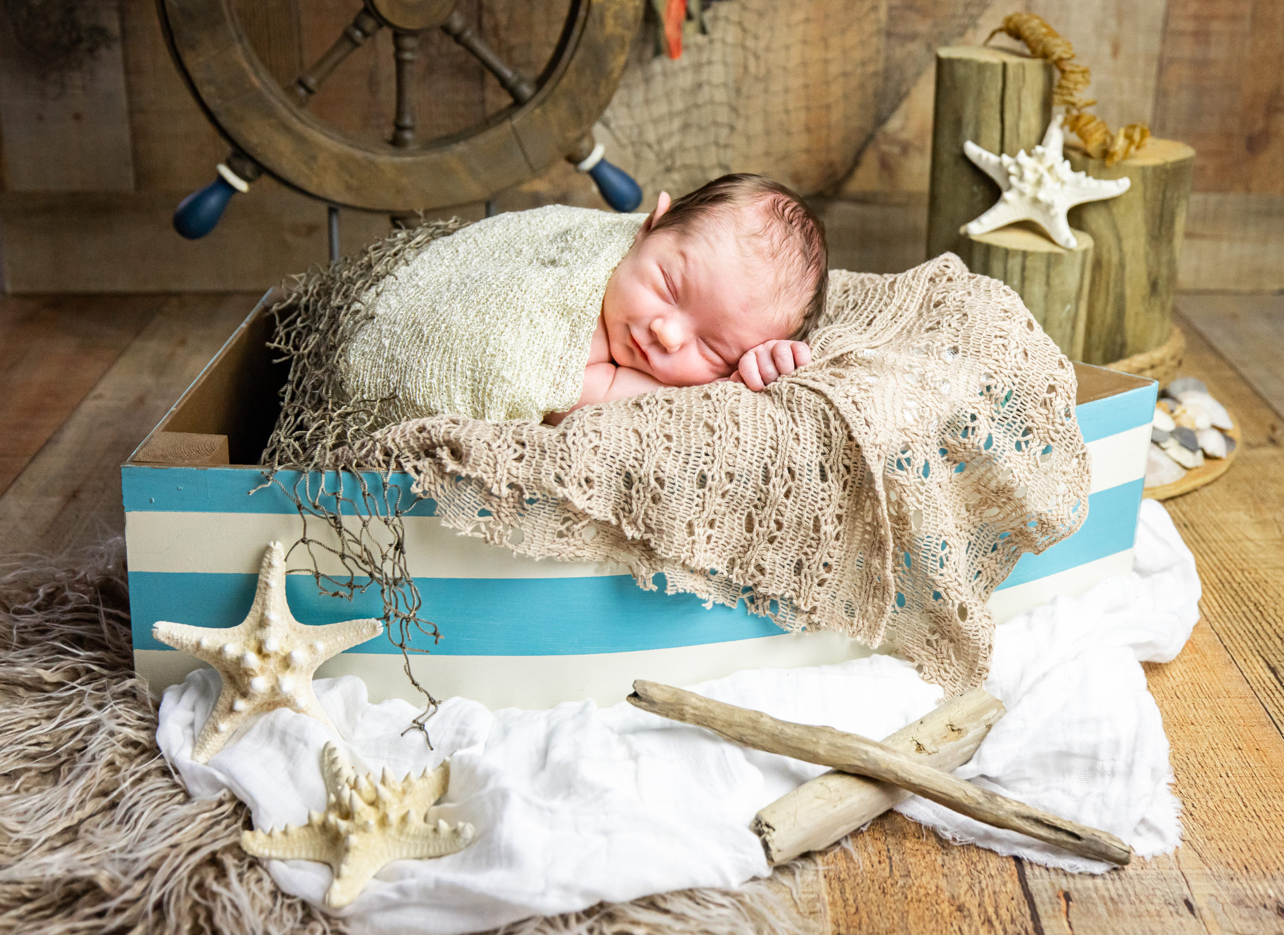 newborn baby in boat with nautical props